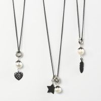 A black Necklace with a Freshwater Pearl & a Metal Charm Pendant