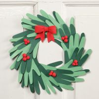 A Christmas wreath made from cut-out card hands with Silk Clay decorations